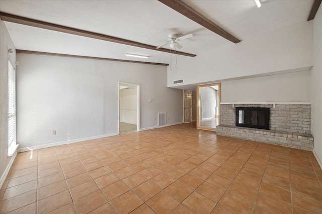 unfurnished living room with lofted ceiling with beams, ceiling fan, a fireplace, and light tile patterned floors