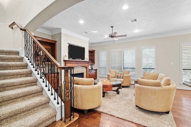 living room with crown molding, hardwood / wood-style flooring, and ceiling fan