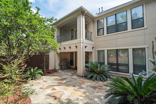 back of property with a balcony and a patio