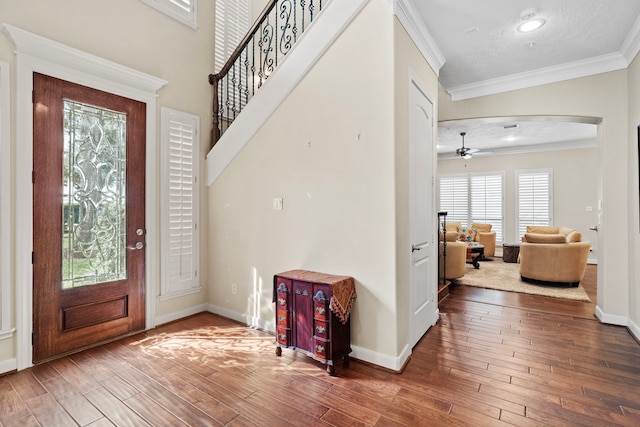 foyer with ceiling fan, ornamental molding, and hardwood / wood-style floors