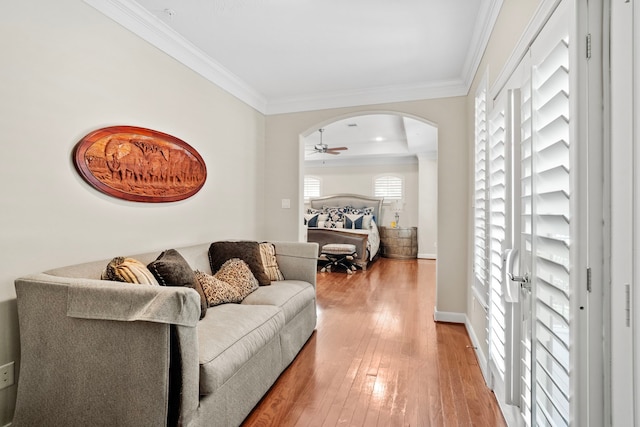 living room featuring ornamental molding, wood-type flooring, and ceiling fan