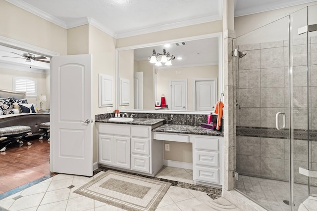 bathroom with a shower with door, wood-type flooring, ornamental molding, vanity, and ceiling fan