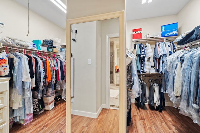 walk in closet featuring hardwood / wood-style flooring and lofted ceiling