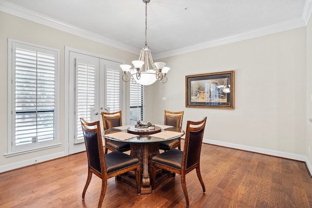 dining area with ornamental molding, a chandelier, and hardwood / wood-style flooring