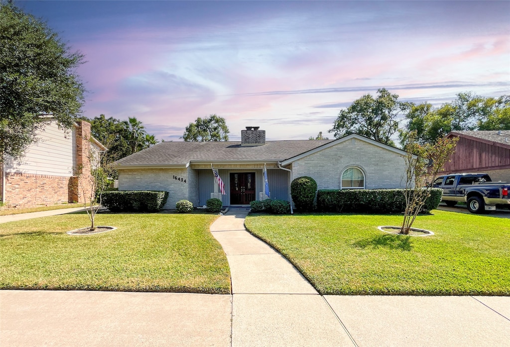 single story home with a lawn