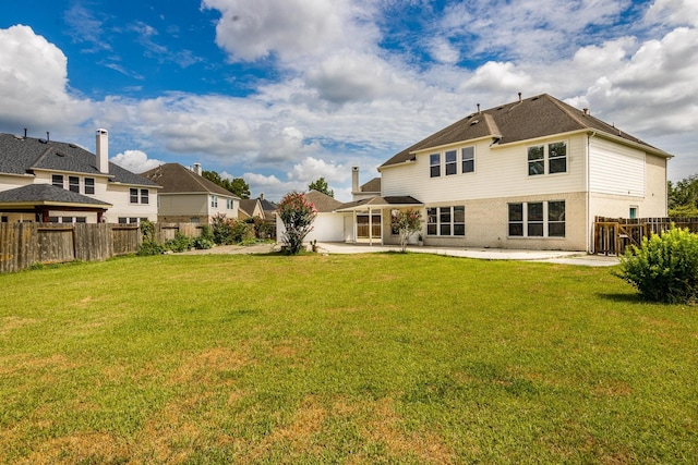 back of house with a lawn and a patio area