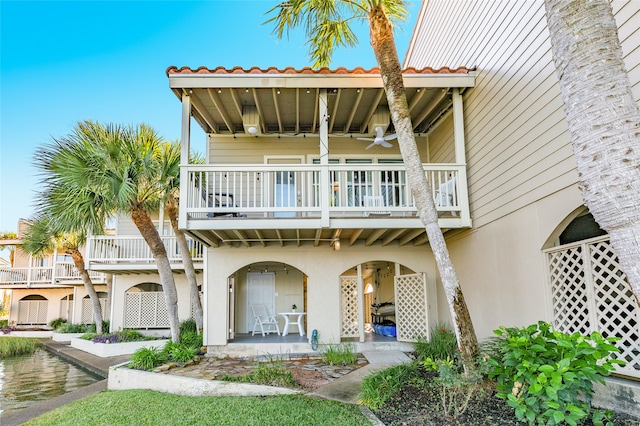 back of property featuring a balcony, a patio, and ceiling fan