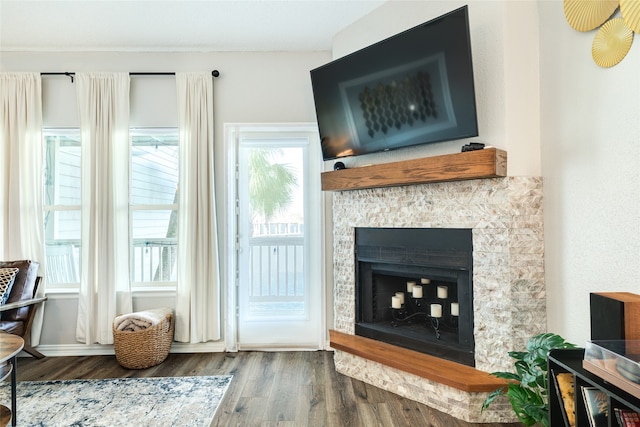 living room featuring hardwood / wood-style flooring, a wealth of natural light, and a tiled fireplace