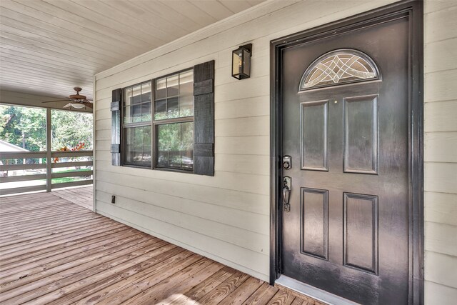 entrance to property featuring covered porch and ceiling fan