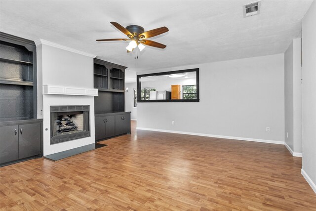 unfurnished living room featuring ornamental molding, a textured ceiling, wood-type flooring, and ceiling fan