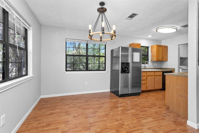 kitchen with light hardwood / wood-style floors, stainless steel fridge with ice dispenser, and a wealth of natural light