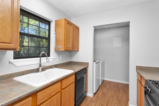 kitchen featuring light hardwood / wood-style floors, black appliances, sink, and separate washer and dryer