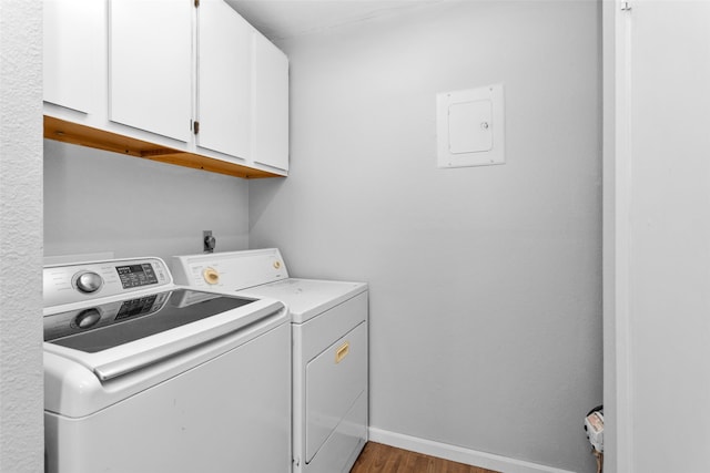 washroom with cabinets, hardwood / wood-style floors, and washing machine and dryer