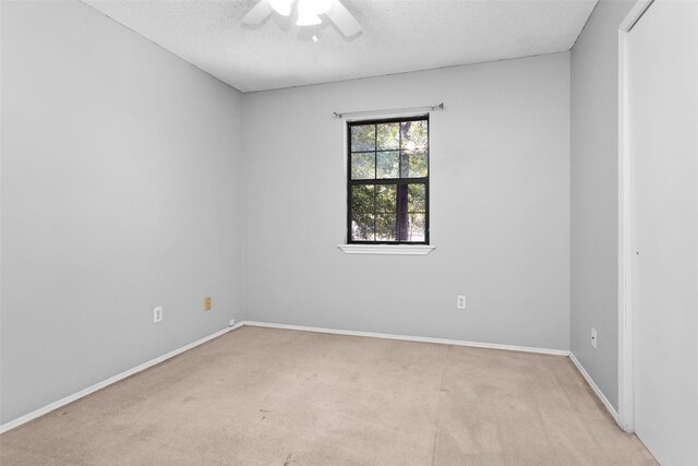 carpeted empty room with a textured ceiling and ceiling fan