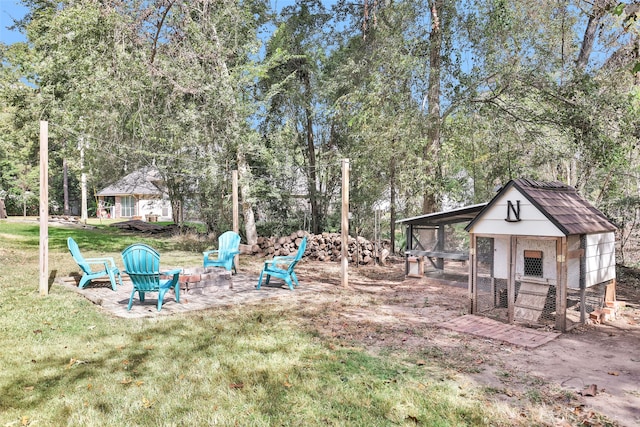 view of yard featuring an outdoor fire pit and an outdoor structure