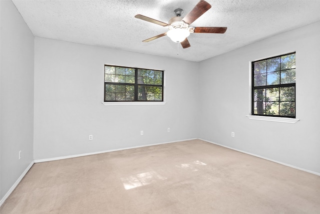 spare room featuring light carpet, a textured ceiling, and ceiling fan