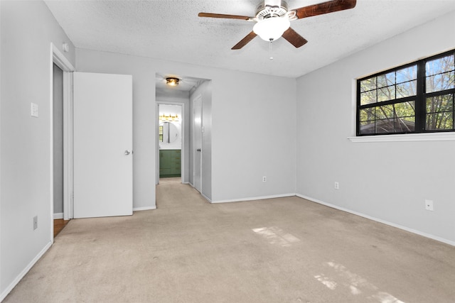 unfurnished bedroom featuring light carpet, a textured ceiling, and ceiling fan