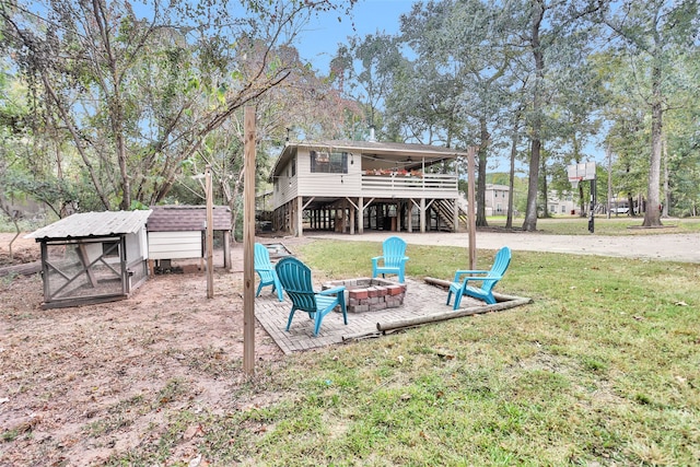 view of jungle gym with an outdoor structure, an outdoor fire pit, and a lawn