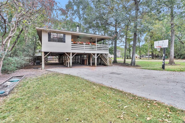 view of front of property with a carport, central AC, a front lawn, and ceiling fan