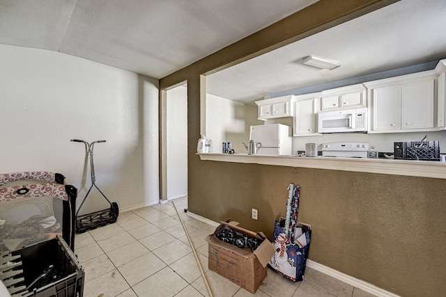 kitchen with white appliances, light tile patterned floors, lofted ceiling, and white cabinets