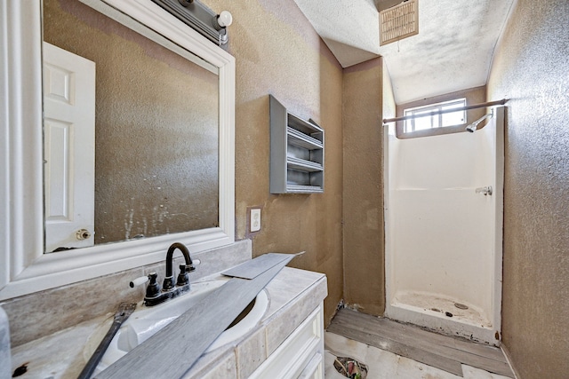 bathroom with vanity, walk in shower, a textured ceiling, and wood-type flooring