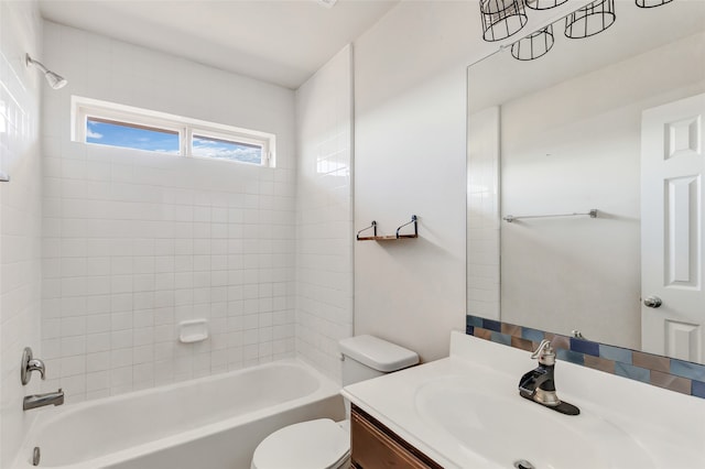 full bathroom with toilet, tiled shower / bath, and vanity