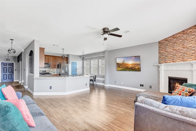 living room with light wood-type flooring and ceiling fan