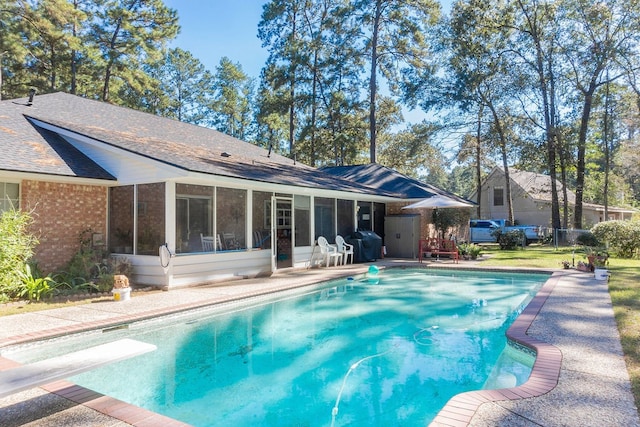 view of pool featuring a diving board, a sunroom, and a patio area