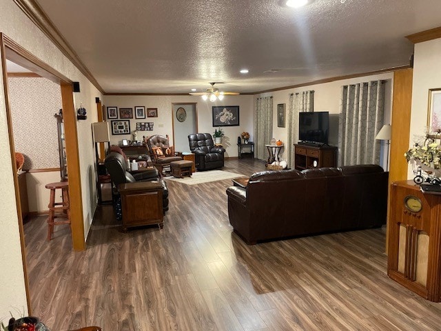 living room featuring ornamental molding, hardwood / wood-style floors, a textured ceiling, and ceiling fan