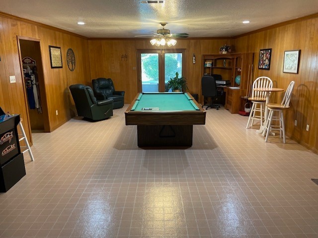 game room with wooden walls and crown molding