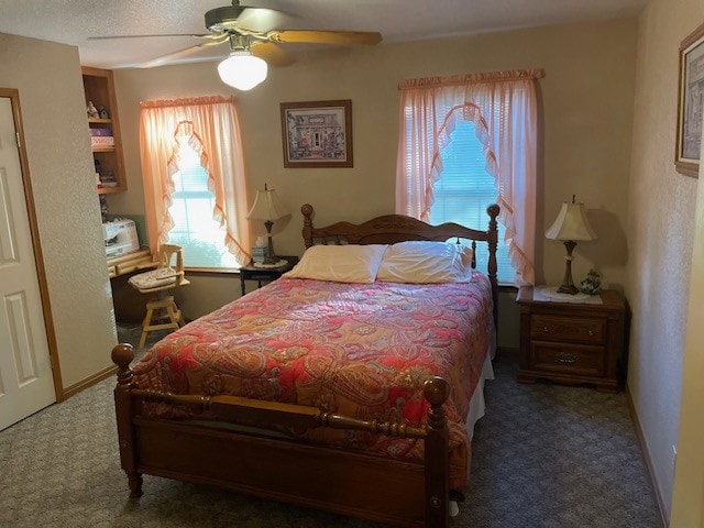 bedroom with dark colored carpet and ceiling fan