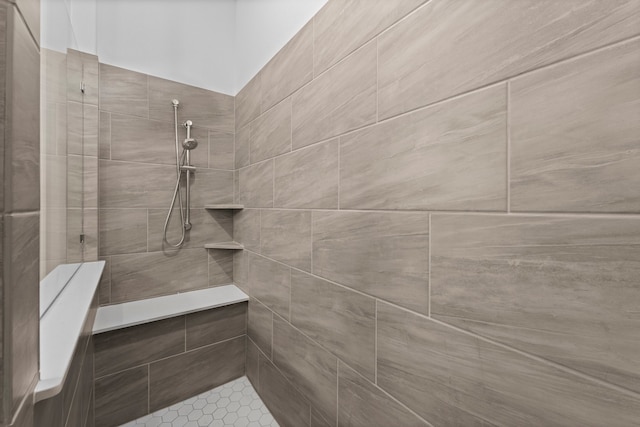 bathroom featuring tile patterned flooring and tiled shower