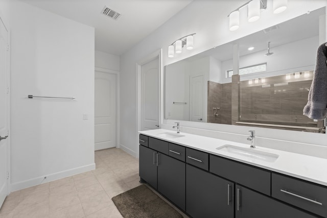 bathroom with vanity, a tile shower, and tile patterned flooring