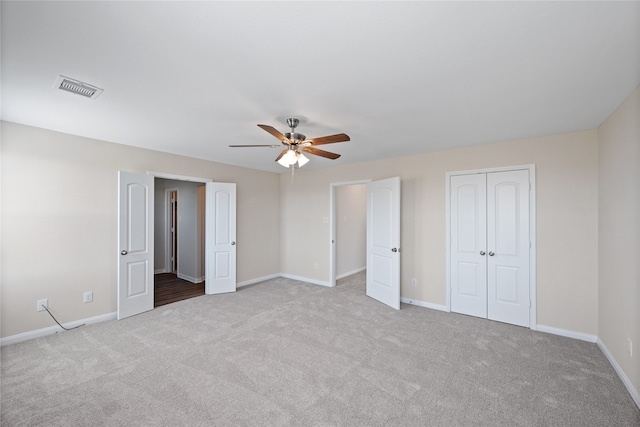 unfurnished bedroom featuring light carpet and ceiling fan