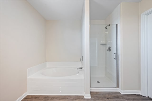 bathroom featuring hardwood / wood-style flooring and plus walk in shower