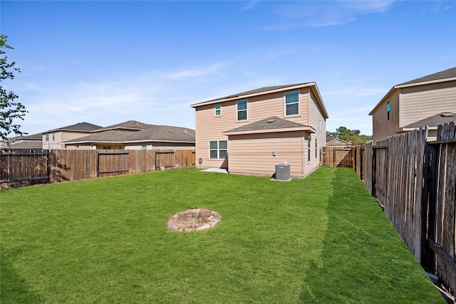 rear view of house featuring a yard and central AC