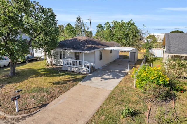 bungalow featuring a front yard, covered porch, and a carport