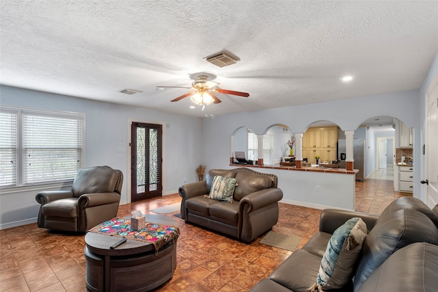 living room featuring french doors, a textured ceiling, light tile patterned floors, and ceiling fan