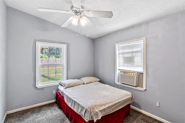 bedroom with cooling unit, a textured ceiling, dark carpet, and ceiling fan