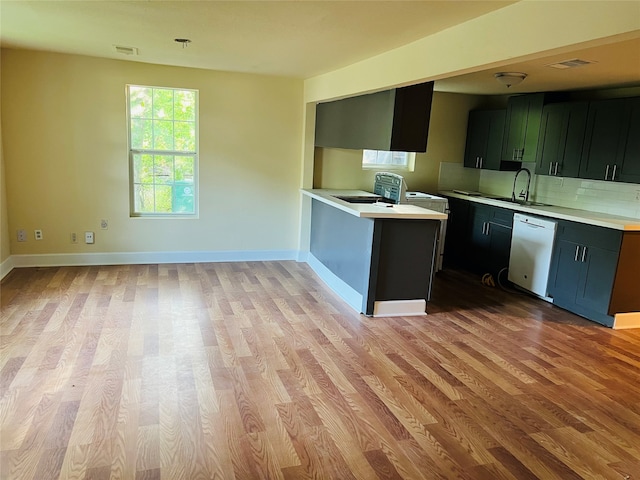 kitchen featuring sink, light hardwood / wood-style flooring, kitchen peninsula, and dishwashing machine