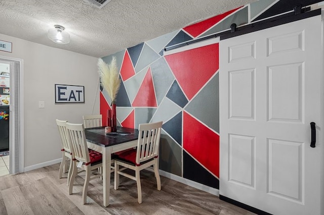 dining room featuring hardwood / wood-style flooring and a textured ceiling