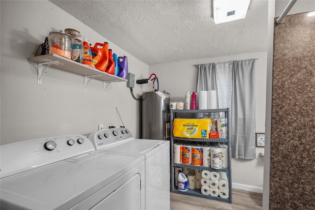 washroom with washing machine and dryer, a textured ceiling, light hardwood / wood-style flooring, and water heater