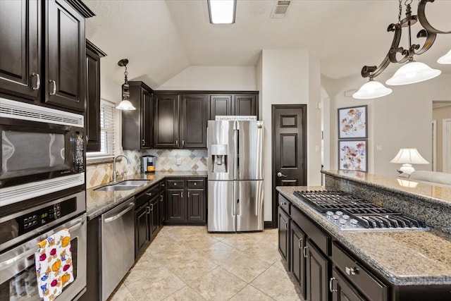 kitchen with appliances with stainless steel finishes, sink, decorative light fixtures, lofted ceiling, and light tile patterned flooring