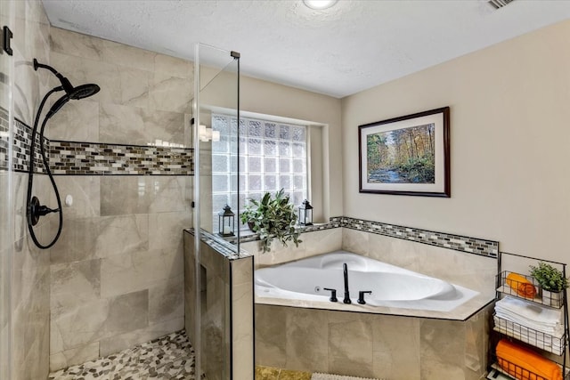 bathroom featuring a textured ceiling and independent shower and bath