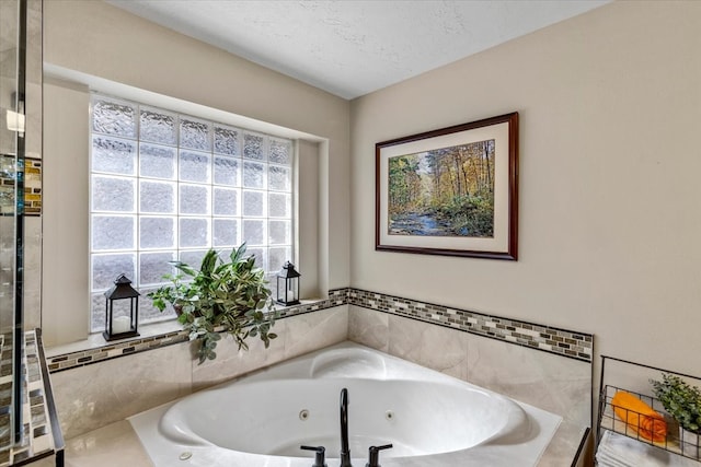 bathroom with tiled bath and a textured ceiling