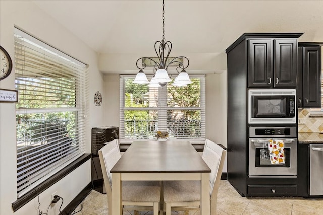 dining area featuring light tile patterned floors and a notable chandelier