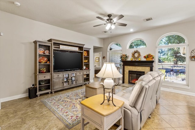 tiled living room with ceiling fan, plenty of natural light, and a premium fireplace