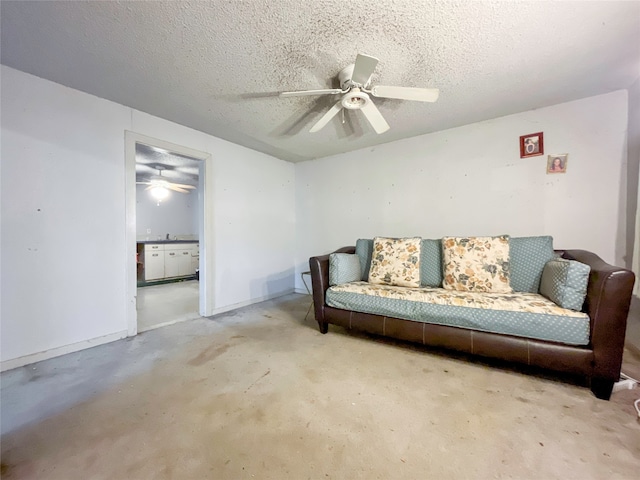 living area with a textured ceiling and ceiling fan