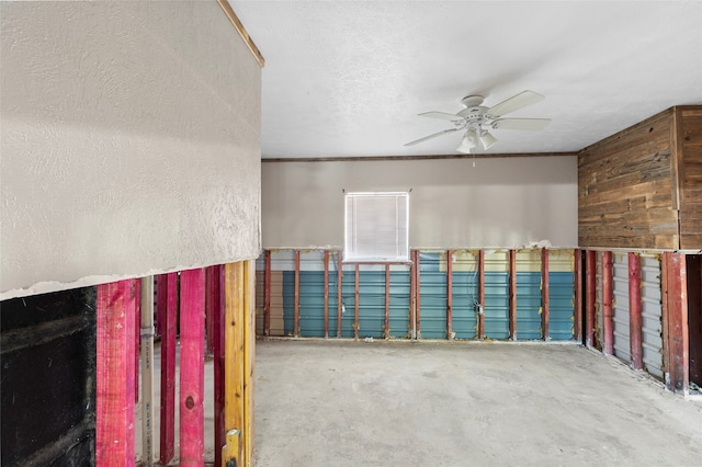 unfurnished room with ceiling fan, a textured ceiling, and concrete flooring