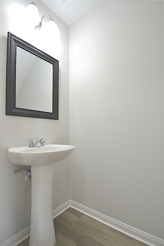 bathroom featuring a textured ceiling, sink, and wood-type flooring